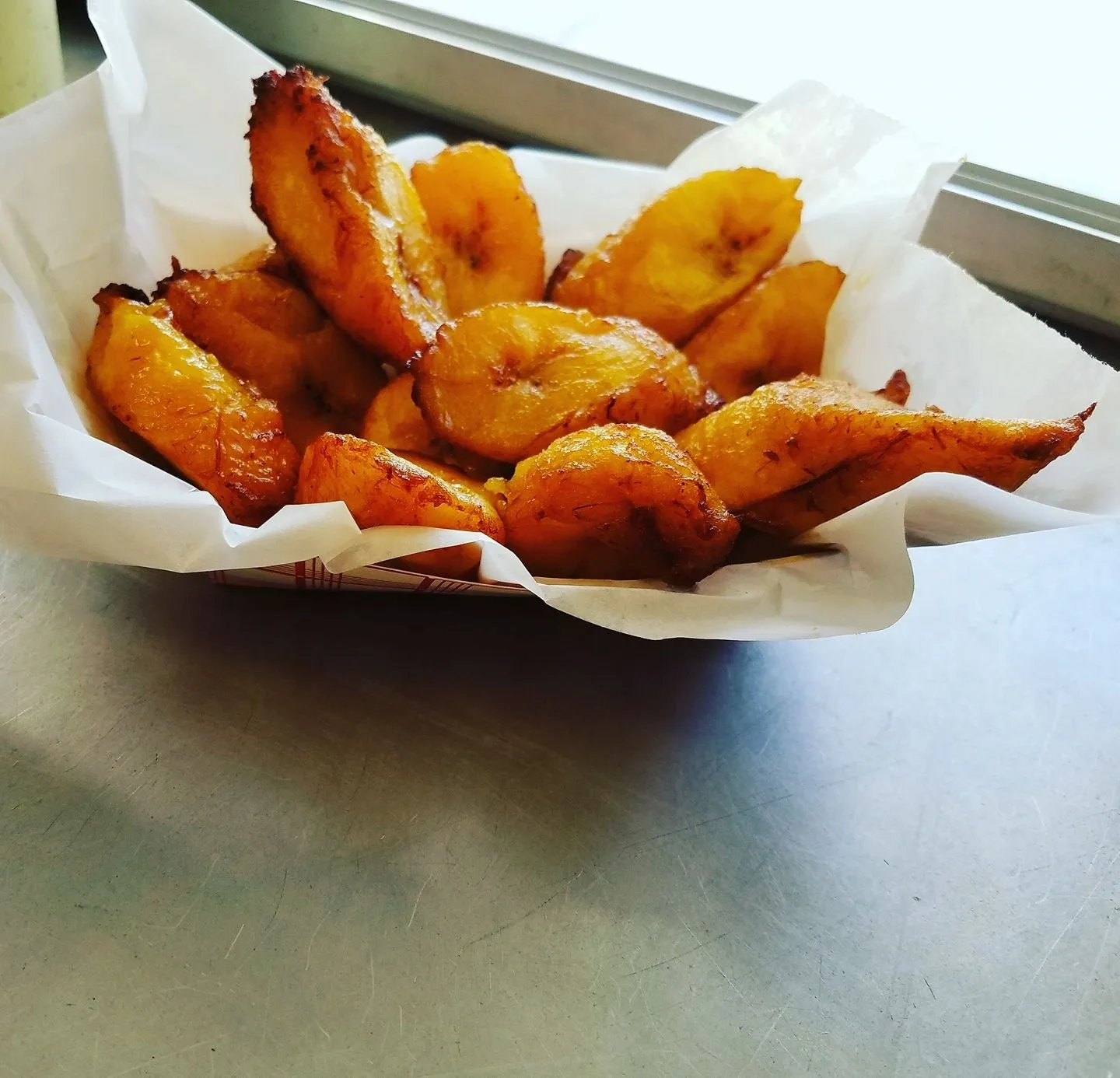 A bowl of fried plantains on top of a table.