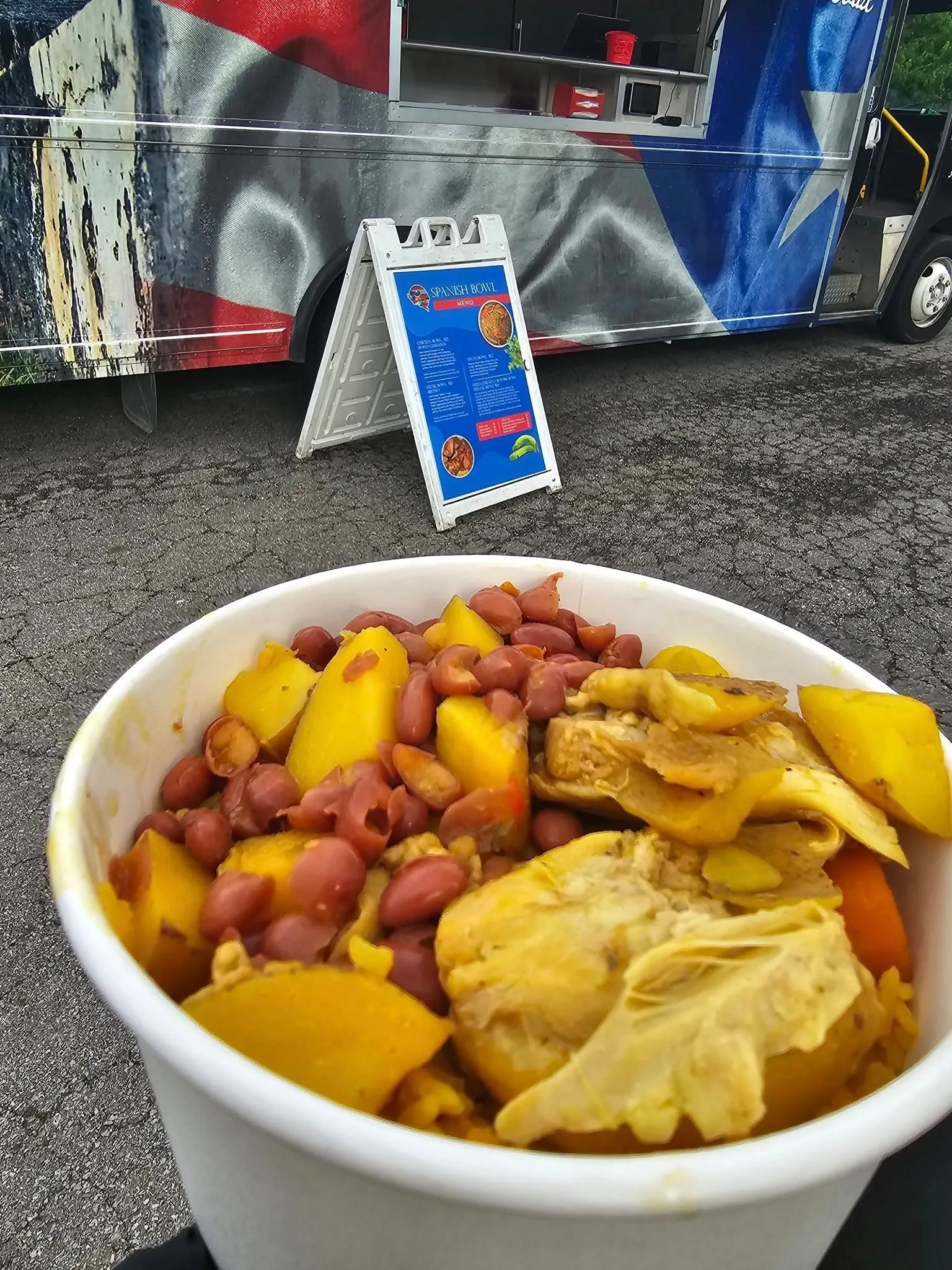 A bowl of food on the ground with a sign in front.