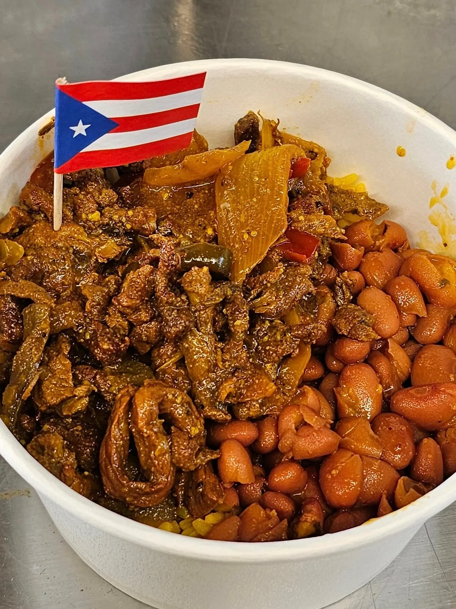 A bowl of food with beans and meat.