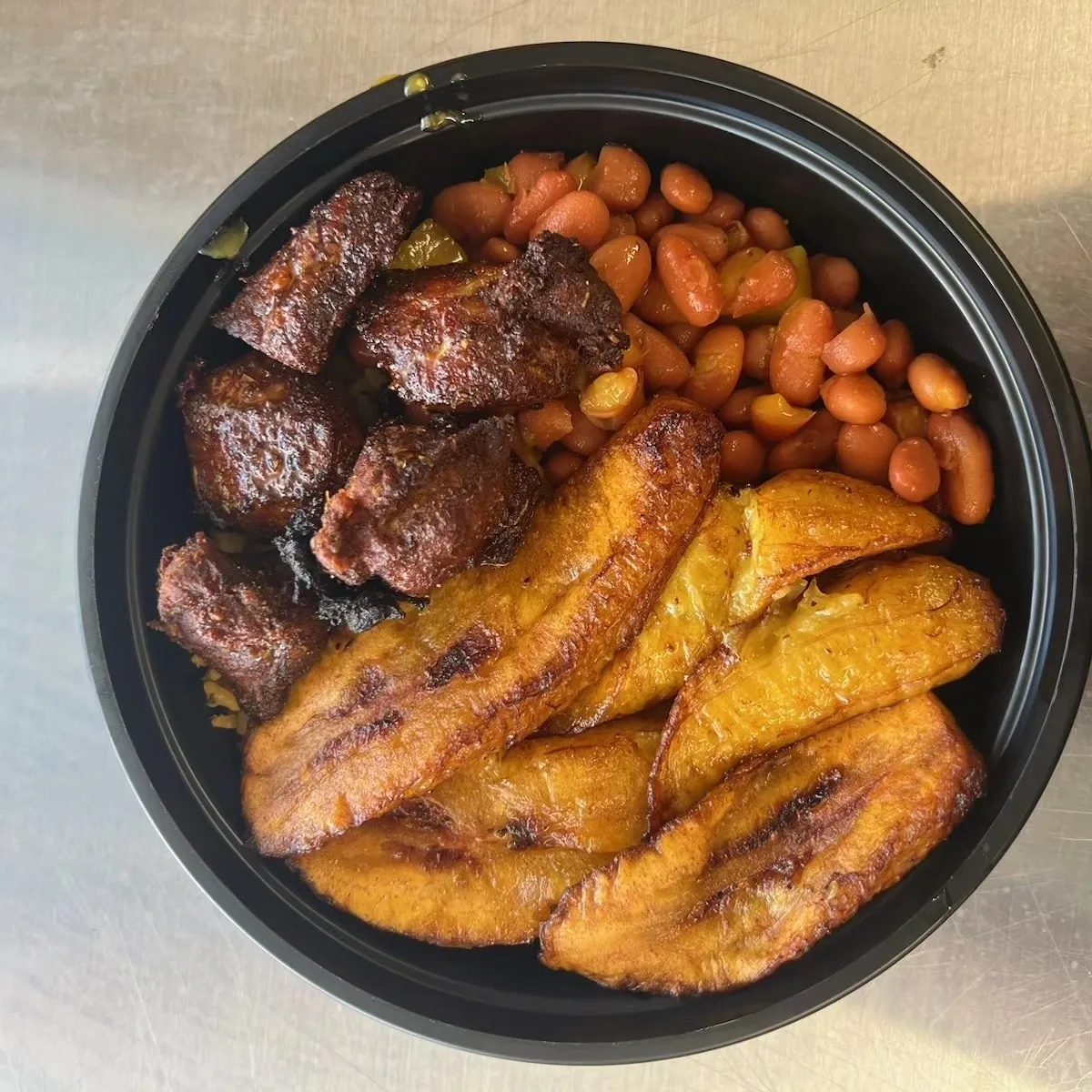 A bowl of beans and meat with some type of beans.